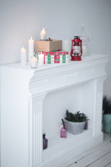blurred image. candles and gift boxes on the fireplace in the li