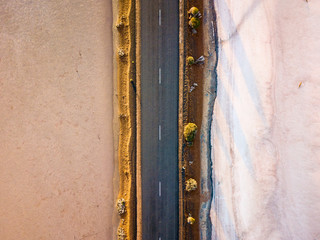 Top down aerial photo of a road (highway) leading through an arid salt lake landscape. Drone photography.