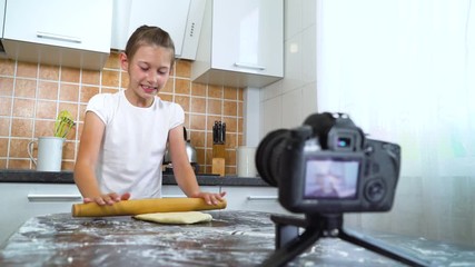Young vlogger recording video content for food blog rolling dough with rolling pin. Cheerful girl sharing secrets live streaming culinary vlog. Communication, healthy food, handmade, network concept
