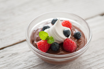 Berries on chocolate pudding with a dollop of cream