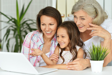 Portrait of a grandmother, mother and daughter using laptop