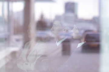 from behind the glass.a confident business team looks out the window of the office