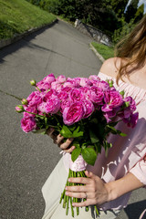 girl with a bouquet of pink roses on a sunny day