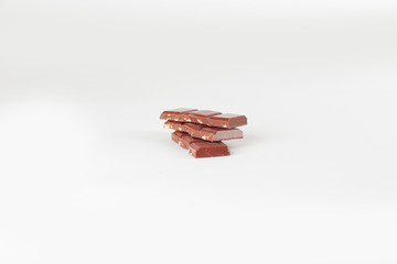 pieces of milk chocolate with nuts isolated on white