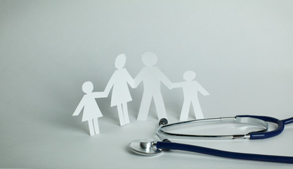 stethoscope and the family paper doll.the concept of health.