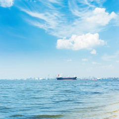 river with ship on horizon and white clouds in blue sky over it