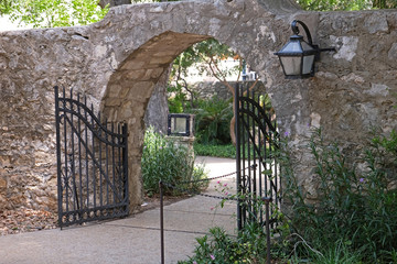 Arch with a wrought iron gate and a wrought iron light