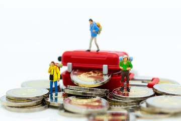 Miniature people : Backpacker group walking on coins. Image use for travel, business concept.