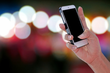 Man using a blank screen smartphone and blurry colorful bokeh background with clipping path on screen panel
