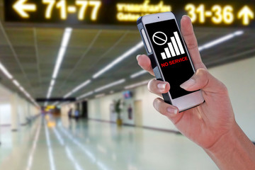 Man using NO SERVICE smartphone at airport and blurry background with clipping path on screen panel