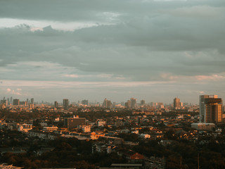 Fototapeta na wymiar Cityscape of unknow city with thick clouds and sunset light.