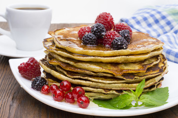 Delicious pancakes with berries and maple syrup. Top