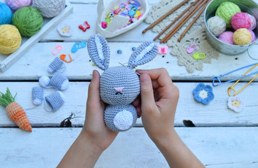Making rabbit with carrot. Crochet bunny for child. On table threads, needles, hook, cotton yarn. Step 2 - to sew all details of toy. Handmade crafts. DIY concept. Small business. Income from hobby.