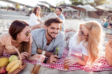 Happy people drinking beer on the beach