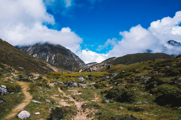 Fototapeta premium Piękny krajobraz z wysokimi górami osiąga szczyt z chmurami. Malowniczy widok na drogę do obozu bazowego Everest Nepal. Górskie tło. Szlak górski. Niesamowita scena z Himalajami. Natura.