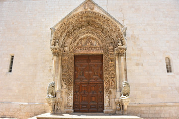 Fototapeta na wymiar Italy, Puglia region, Altamura, Cathedral of Santa Maria Assunta, gate and sculptures of the main façade.