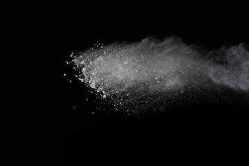 White powder explosion isolated on black background. Colored dust splatted.