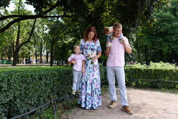 Naklejka na ściany i meble happy caucasian family in park
