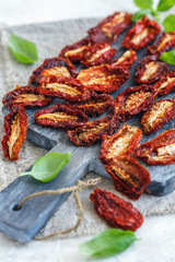 Homemade sun-dried tomatoes on cutting board.
