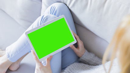 Woman relaxing reading on the tablet computer with pre-keyed green screen