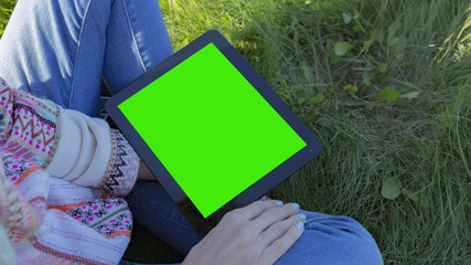 Woman relaxing reading on the tablet computer with pre-keyed green screen