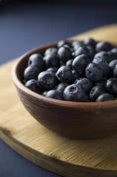 Blueberries in the bowl on a black slate
