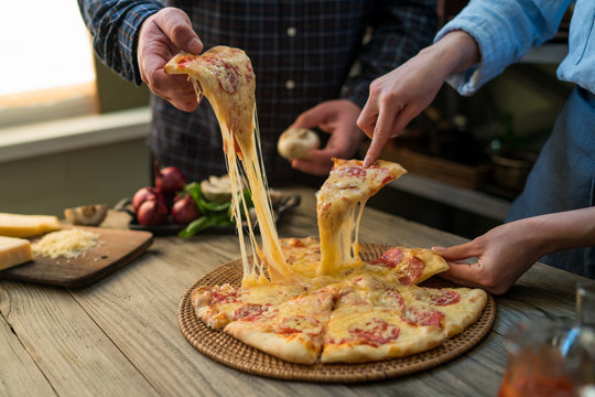 Slice Of Hot Pepperoni Pizza, Large Cheese Lunch Or Dinner With Cheese. Delicious Tasty Fast Food Italian Traditional On Wooden Board Table Classic In Side View. People Hands Taking Slices Of Pizza.