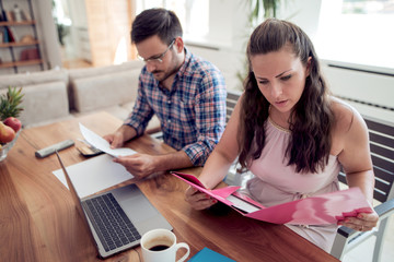 Young couple looking at family finance papers