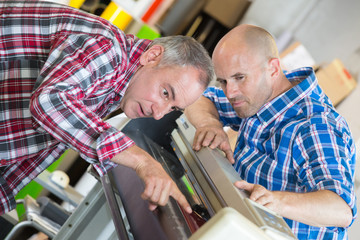 male technicians repairing digital photocopier machine
