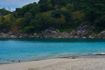 Tropical white sandy beach with rocky mountains and clear water of Indian ocean. View of turquoise bay with rocks  with lush tropical forest. Clear water of the lagoon. Turquoise water background.