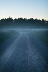 Foggy country dirt road after sunset