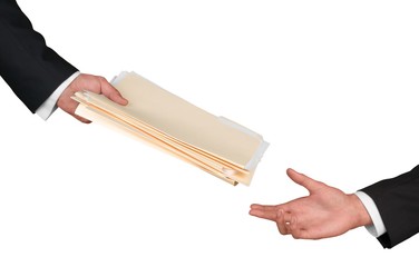 Closeup of Businesspeople Handing File Folders
