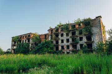 Ruined overgrown apartment house with bullet marks in ghost town, consequences of war in Abkhazia,...