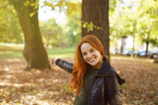 Pretty woman pointing to a colorful autumn park