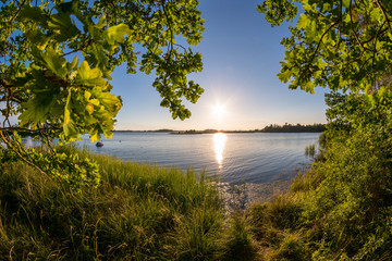 Beautiful view at a sunset behind blue water © DZiegler