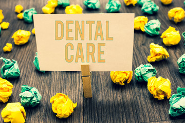 Handwriting text writing Dental Care. Concept meaning maintenance of healthy teeth or to keep it clean for future Clothespin holding light pink note paper crumpled papers several tries.