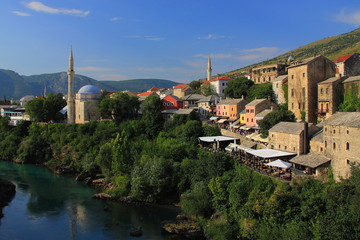 Fototapeta na wymiar Mostar in Bosnia and Herzegovina - landscape with the Neretva River and Mosque of Koski Mehmed Pasha seen from the Old Bridge.