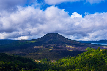 Beautiful banner with mountain landscape and tropical forest. Landscape of Batur volcano on Bali island, Indonesia. View far away beauty, inspiring mountain, fresh blue sky. Summer day.
