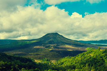 Fototapeta na wymiar Beautiful banner with mountain landscape and tropical forest. Landscape of Batur volcano on Bali island, Indonesia. View far away beauty, inspiring mountain. Summer day. Instagram filter photo.