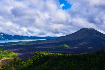 Fototapeta na wymiar Summer background. Rural sunrise landscape. Countryside and green tropical forest. Natural background. Landscape of Batur volcano on Bali island, Indonesia. Azure lake in the mountains.