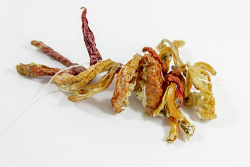 Angled close-up shot dried orange colored pepper on white background
