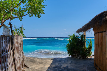 Beautiful seascape with a noisy foaming waves and beach bamboo hut view towards the turquoise...