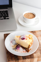 Сoffee cappuccino and dessert cheesecake at the work table. concept of lunch in office at work. breakfast for laptop. top view.