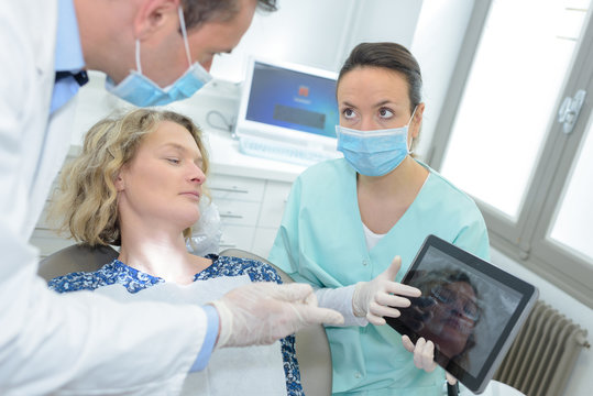 dentist with x-ray on tablet pc computer and girl patient