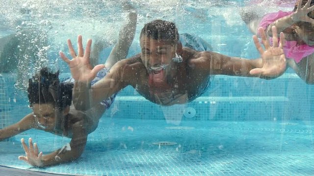 Cheerful pretty family having fun together in swimming pool