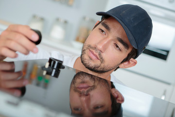 Young man installing kitchen hob
