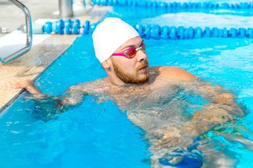 Swimmer in a white hat to prepare for a workout standing in the pool