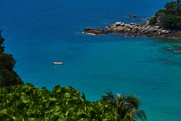 Obraz premium Nature and marine landscape. Turquoise ocean waters. Paradise lagoon, rock bay and large palm trees next to the seashore.
