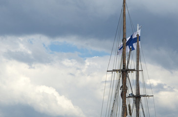 Obraz premium Flag of Finland on the mast of the yacht in the blue sky.
