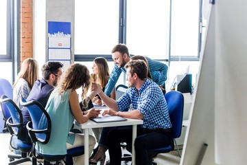 Business colleagues sitting at the table compete with each other arm wrestling